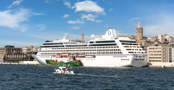 Nautica Majuro, Huge cruise ship docked at terminal of Galataport, a mixed use development located along the Bosphorus, in Karakoy neighbourhood, with Galata tower in the far end, Istanbul, Turkey