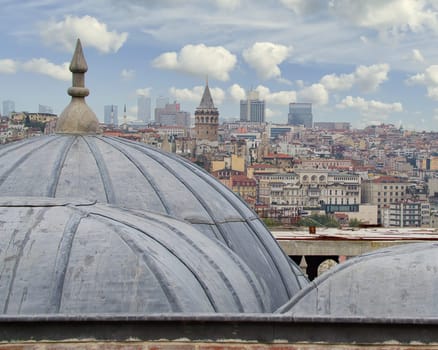 Shot from external court of Suleymaniye Mosque, of Istanbul city, including Galata Tower, framed by domes of Ibn Haldun University, Istanbul, Turkey
