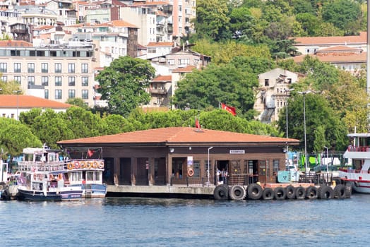 Istanbul, Turkey - September 1, 2022: Golden Horn, Kasim Pasa Ferry Terminal with houses and dense green trees in the background