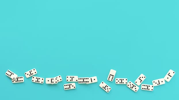 Fallen domino pieces on a pale blue background.
