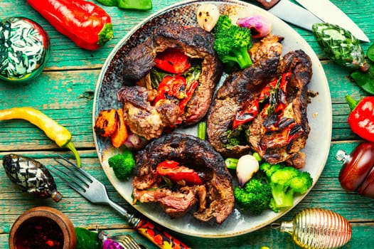 Roasted meat with vegetable garnish on cutting board