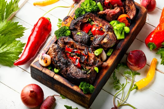 Roasted meat with vegetable garnish on cutting board