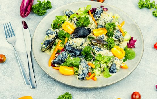 Plate with a salad of fresh vegetables, herbs and mussels.