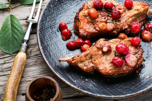 Tasty steaks prepared in a cherry marinade. Grilled meat on rib in berry sauce