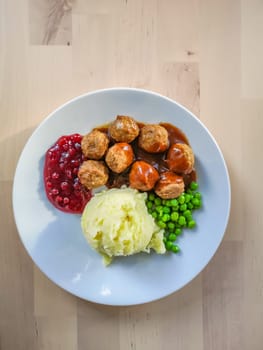 Traditional Swedish dish - meatballs with lingonberry sauce, mashed potatoes and green peas.
