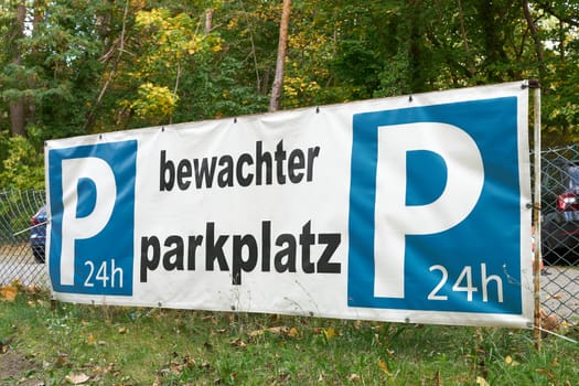 Guarded parking lot for german vacationers in the city center of Swinoujscie in poland. Sign with the inscription guarded parking 24 hours