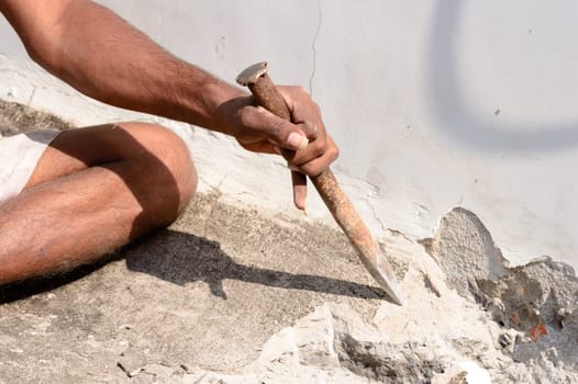 Close up Part of a construction labor working with hammer and Chisel in a construction site.