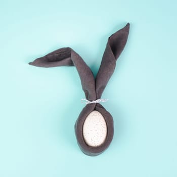 Easter bunny, wrapped egg with a cloth, minimal spring holiday concept