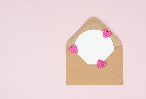 Valentine day greeting card, envelope with hearts on pastel background, love symbol, flat lay