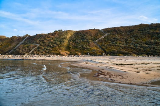 Coastal landscape in Denmark with sandy beach and waves in the ocean. Ocean landscape photo