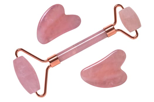Gua Sha massage tools. Close-up of a pink jade facial roller or beauty roller and Rose quartz stones for better blood circulation and muscle activation. Clipping path. Beauty concept. Isolated on white.