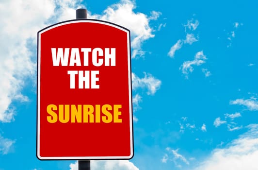 Watch The Sunrise motivational quote written on red road sign isolated over clear blue sky background. Concept  image with available copy space