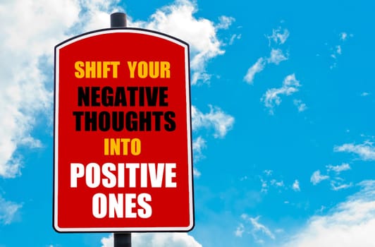 Shift Your Negative Thoughts Into Positive Ones motivational quote written on red road sign isolated over clear blue sky background. Concept  image with available copy space