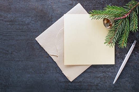 Christmas fir tree branch with paper card empty note and pen. Flat lay. Nature New Year holiday concept, top view, copy space