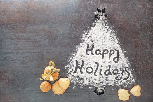 Happy Holidays written text made with flour decorations with cookies. Holidays, baking celebration background