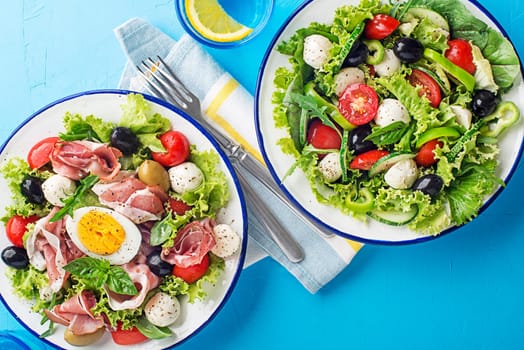 Healthy green salads with mixed healthy ingredients on blue table background