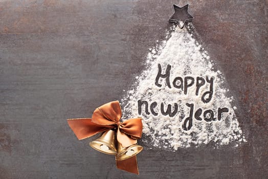 Happy New Year written text made with flour with decorations objects. Holidays, celebration background. Christmas and New Year background