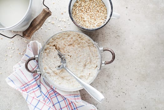 Oatmeal plate. Cooked oatmeal served with fresh milk. Healthy food, diet. Top view.