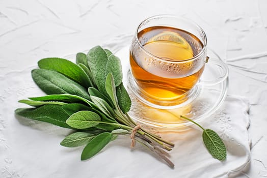 Sage tea cup and sage leaves on white table close up