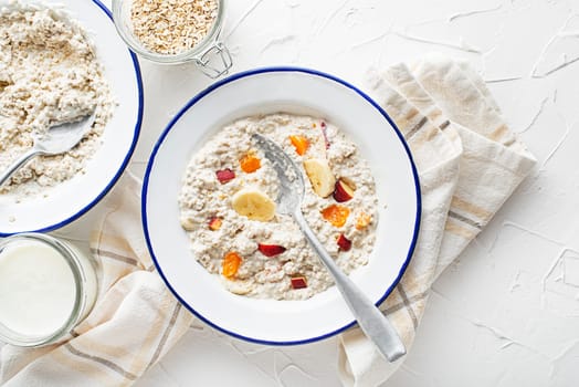 Oatmeal plate. A plate of oatmeal served with fresh fruit and milk. Healthy food, diet. Top view.