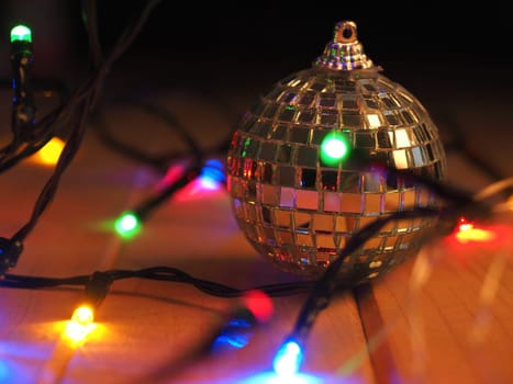 Christmas decoration disco ball on a wooden floor with festive Christmas lights