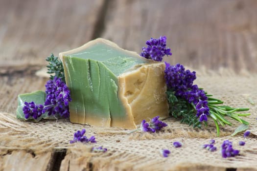 Natural handmade soap with herbs on rustic wooden background