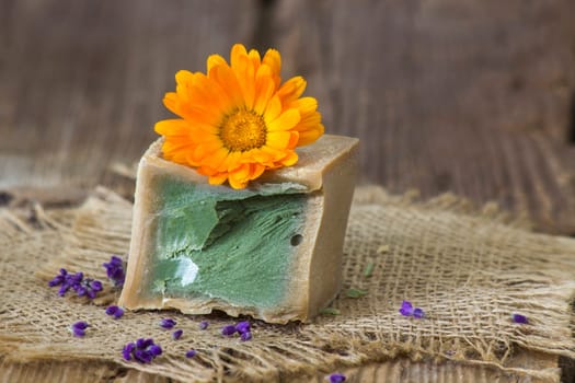 Natural handmade soap with calendula flower on rustic wooden background