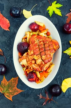 Delicious pork shoulder with skin and bacon roasted with plums.
