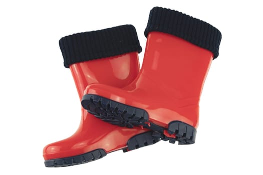 Childrens shoes and boots. Closeup of seasonable red rubber boots or gumboots isolated on a white background. Clipping path. Kids shoe fashion.