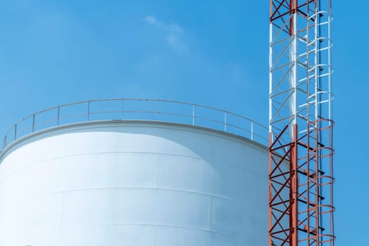 Large white water tank with blue sky.