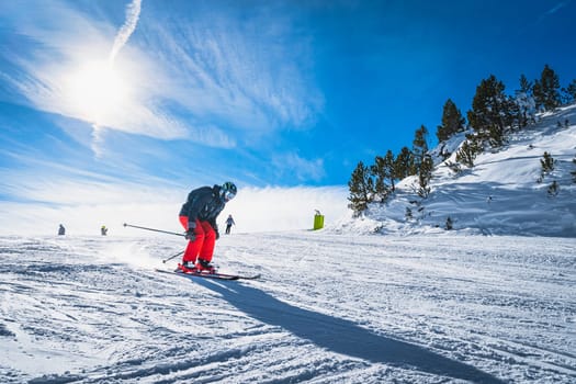 Man skiing down the ski slope or piste in Pyrenees Mountains. Winter ski holidays in El Tarter, Grandvalira, Andorra