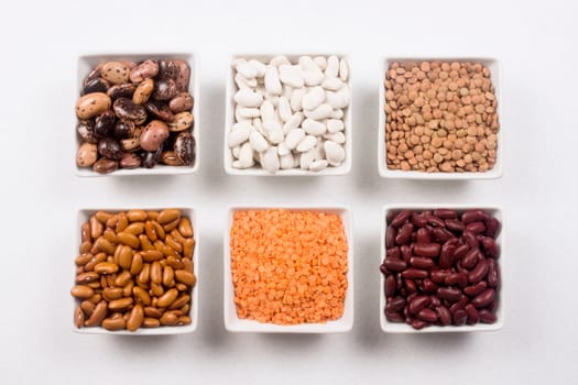 Different food ingredients from legume family like beans and lentils on white background.