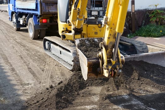 Repaving the road, The excavator is leveling gravel on the road, making a base for laying the asphalt.