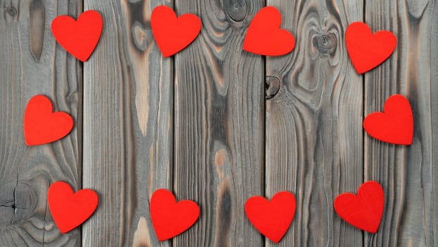 Cute small red hearts laying with hole in circle on dark wood background. Saint Valentines Day, women day or mother day loving greeting card. Memory gift from the heart. Flat lay, copy space