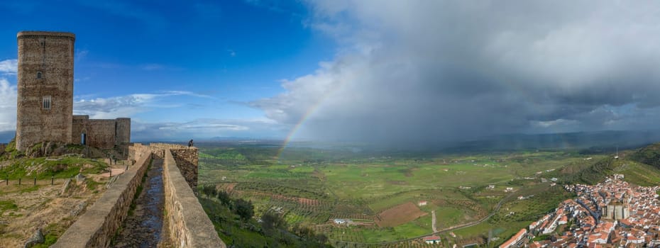 Panoramic of Feria, Badajoz, Spain. The rainbow stretches from the castle to the village