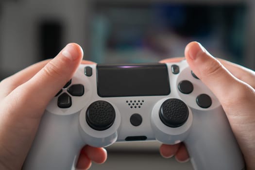 Male hands hold modified plastic joystick closeup, selective focus. Person play videogames. Hold wireless game console. Press buttons on controller by fingers. Modern technologies and gaming.