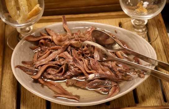 There are many sprats in a bowl on the buffet.