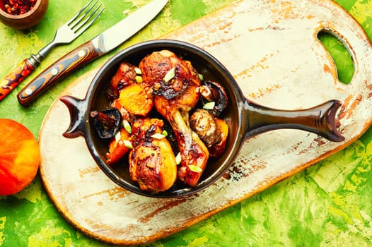 Chicken drumsticks baked with pumpkin on the plate. Copy space