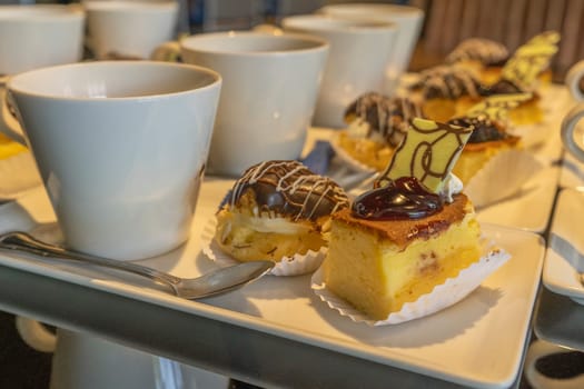 Coffee break cups of hot coffee and cakes on wooden table