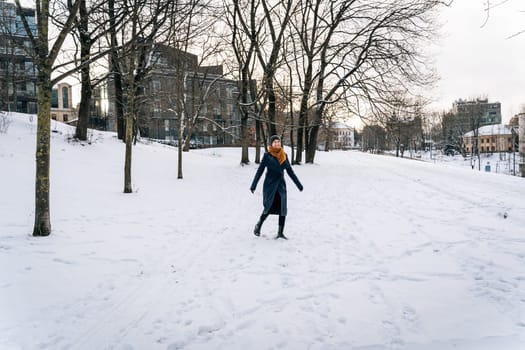A cheerful woman against the backdrop of a winter city during a walk.
