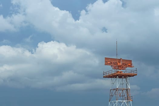 Red-and-white airport radar in daylight