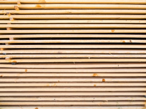 Full framed view of new softwood boards stacked parallel on top of each other.
