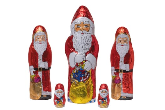 Chocolate Santa isolated. Close-up of five cheerful wrapped chocolate Santa Claus or the good Saint Nicolas figurine isolated on a white background. Macro photograph.