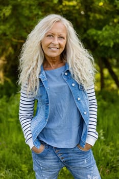Beautiful elderly woman with her hands in pocket in a public Park