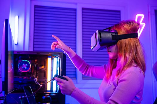 Gamer in VR headset glasses exploring metaverse plays online video game touching something on air with neon lights, Excited woman playing watching video life simulation at home