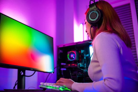 Asian woman gamer wearing gaming headphones holding joystick console to play video game and streaming online on computer PC neon light at home, tournament player E-Sport concept