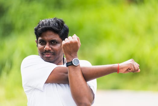 Close up Asian young sport runner black man wear watch he body warming up arms muscles before running at the outdoor street health park, healthy exercise Injury from workout concept