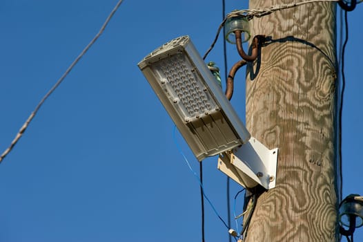 The LED street light is attached to a wooden pole