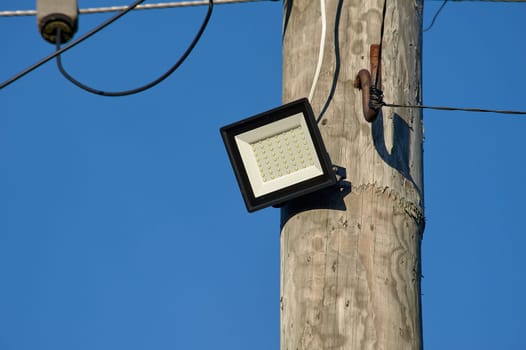 The LED street light is attached to a wooden pole