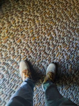 Man stepping on pebbles floor. Traditional south spanish flooring techique